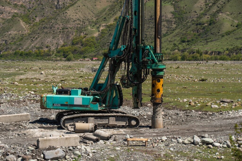 A heavy drilling machine in use on a rugged outdoor construction site.
